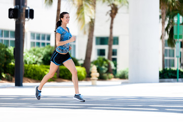 Fototapeta na wymiar Young woman running jogging on downtown street
