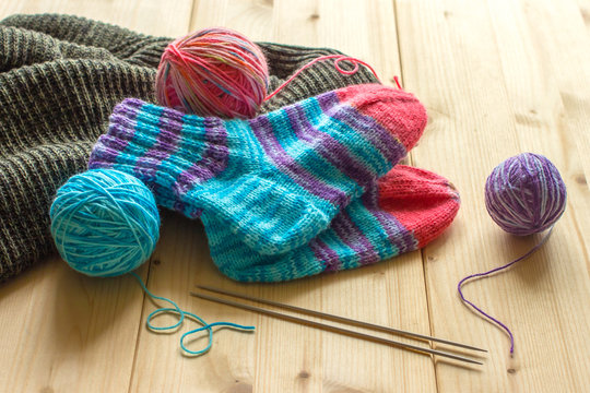 Handmade baby socks, multicolor skeins and knitting needles