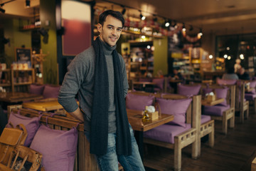 Young handsome man standing and posing in the restaurant