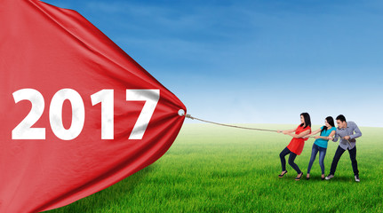 People dragging number 2017 at field