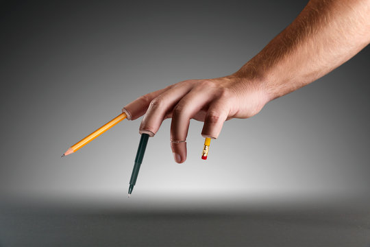Hand with pen and pencils instead of fingers