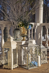 Fototapeta premium Wedding decor. White and grey steel lanterns surround a vase wit