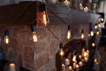 Shining electric bulbs hang over the stone fireplace