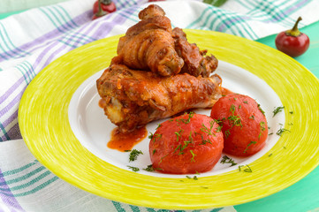 Chicken legs with tomato sauce and marinated tomatoes without skins in their own juice. The top view.