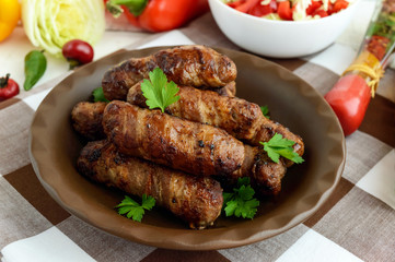 Juicy grilled rolls of minced meat wrapped in bacon.
