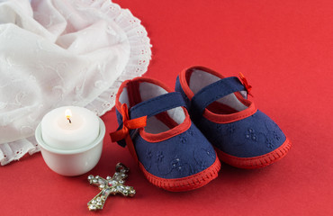 Christening background with booties, candle and Christian cross