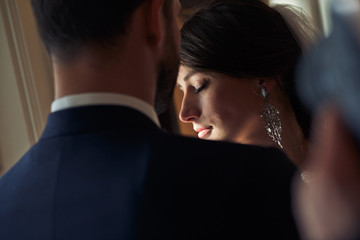 A look from groom's shoulder on tender bride's face