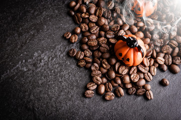 Halloween pumpkin decoration with coffee beans on dark background
