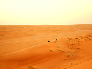 Fototapeta na wymiar Two women sitting in the Wahiba desert, Oman