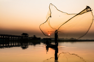 Fisherman cast a net in the Taung tha man lake, Mandalay, Myanmar