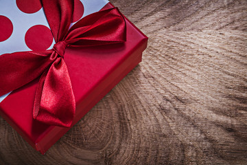 Red present box with bow on wooden board celebrations concept
