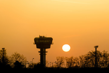 Airport control tower silhouette at sunrise