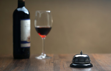 Service bell and red wine on the table