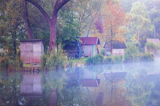 Small fishing huts next to lake in autumn