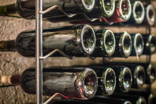 bottles of red wine on iron shelf