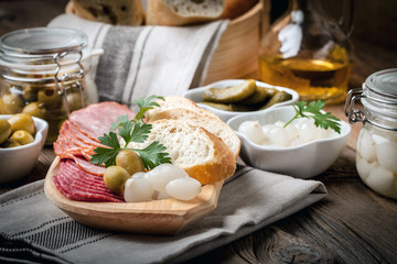 Tapas with sliced sausage, salami, olives, marinated onions, cuc