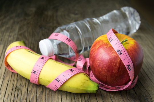 Healthy eating concept, tape measure, fruit and water bottle on