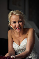 Fototapeta premium Sincere laugh of the blonde bride in the wedding dress