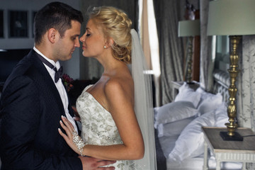 Naklejka premium Sensual embracement of the newlyweds in the luxury hotel