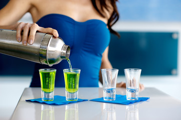 Young Woman Bartender Pouring Green Shot of Liquor