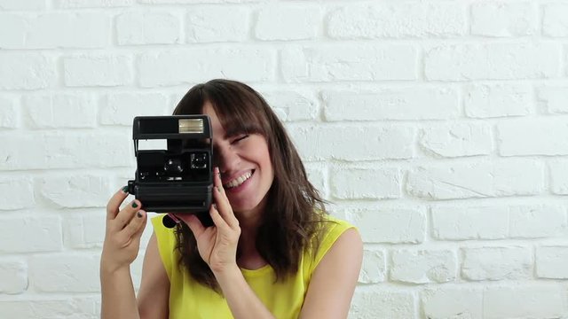 Beautiful woman taking a picture with instant camera
