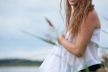 Чувственная девушка с белым шарфом на берегу озера