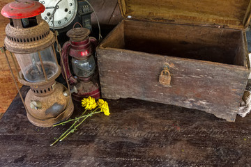 Vintage oil lamp ,old wooden box ,dry chrysanthemum flower and alarm clock on old wooden touch-up in still life concept