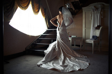 The charming bride stands near stairs