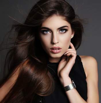 beautiful girl with dark hair and bright makeup in elegant dress
