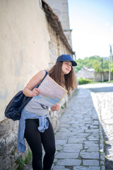 Girl tourist with a map watching something