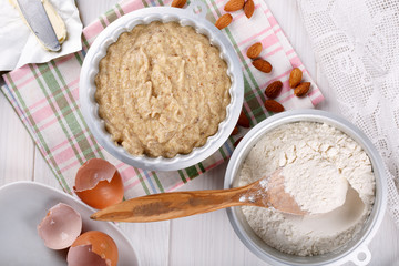 Raw batter for almond cake and ingredients for baking