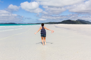 Happy running woman on beautiful beach in the Whitsunday Islands in Australia