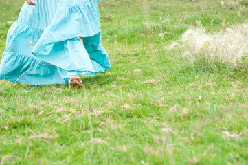 Девушка в голубом длинном платье босиком на зеленой траве