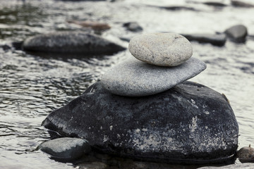 Fototapeta na wymiar Rock cairn by calm water.