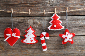 Christmas decoration hanging on rope on wooden background