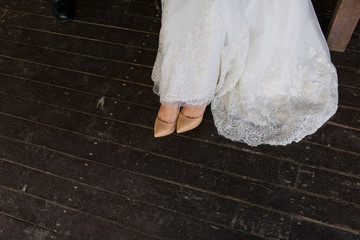 Fototapeta na wymiar Lace trail of the dress and elegant shoes