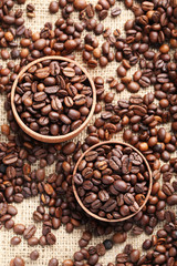 Brown roasted coffee beans in bowl on sackcloth