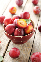 Fresh plums on a grey wooden table