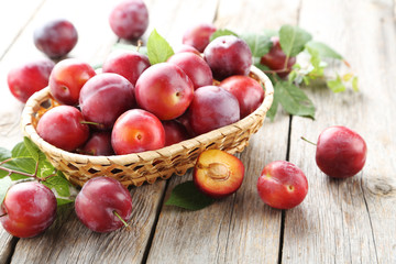 Naklejka na ściany i meble Fresh plums on a grey wooden table