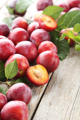 Fresh plums on a grey wooden table