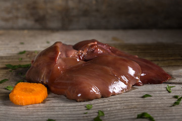 Raw chicken liver on wooden table
