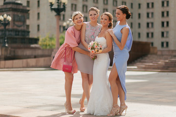 Joyful bride with the bridesmaids in the colorful dresses