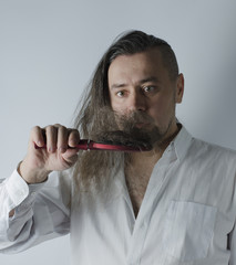 a man looking at a hairbrush