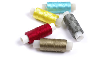 Fototapeta na wymiar Spools of multicolored silk threads on white background