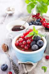 Delicious chocolate dessert with berries and mint served in ramekin.