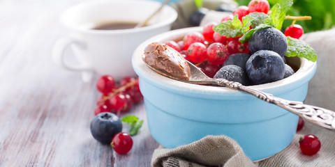 Delicious chocolate dessert with berries and mint served in ramekin. Copy space