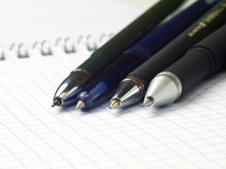 set of ballpoint pen on open spiral notebook, macro, shallow depth of field