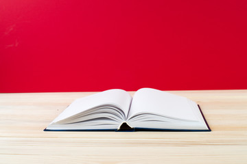 Open book, stack of hardback books on wooden table. Back to school. Copy space