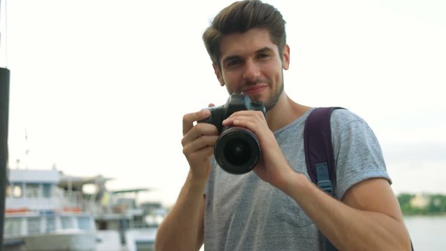 Portrait of professional photographer using his photo camera.