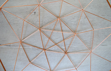 Copper geometric shape pattern on white wood background